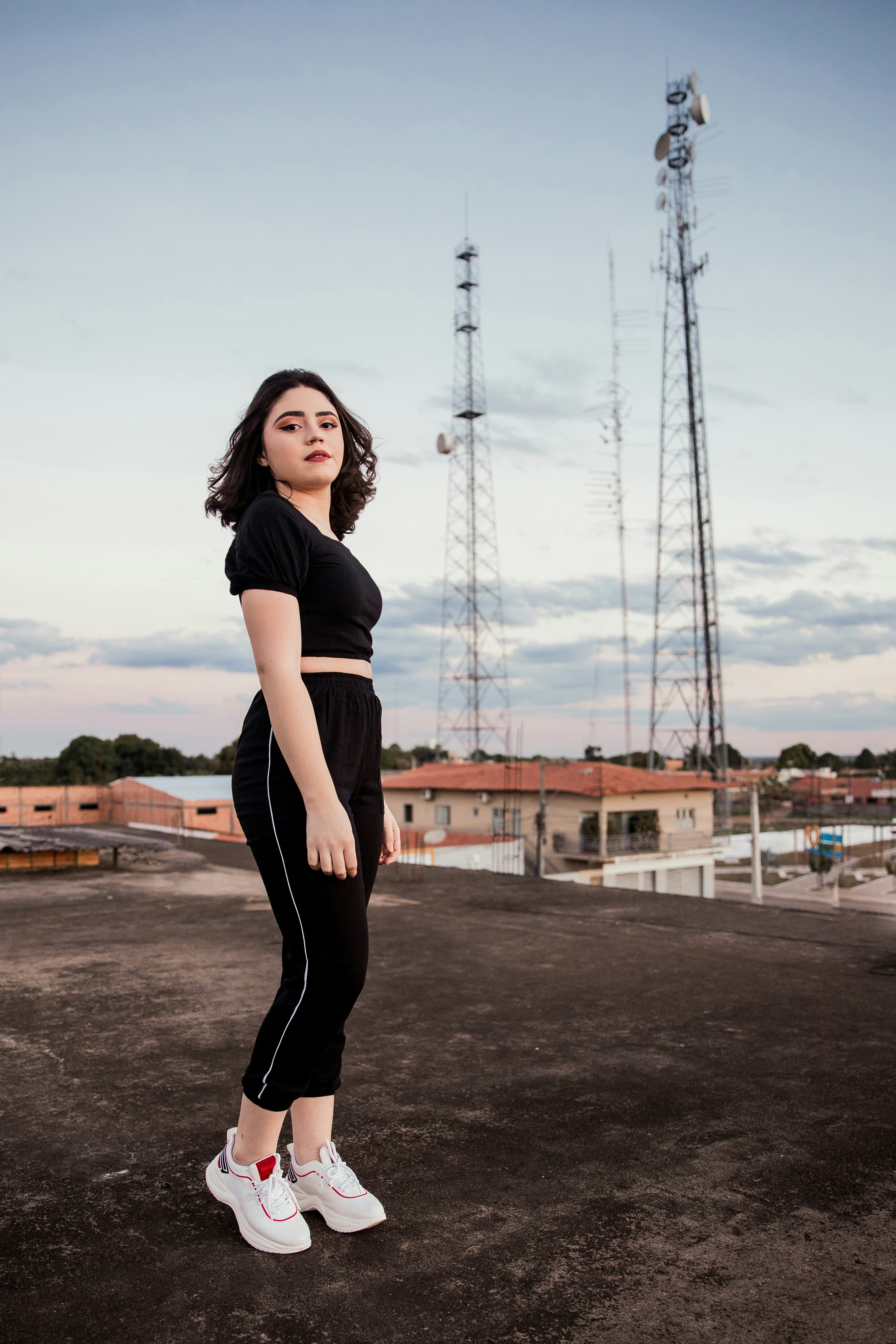 woman in black dress standing on road during daytime